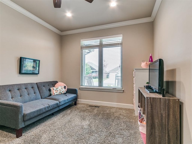 living room featuring crown molding, baseboards, ceiling fan, and carpet