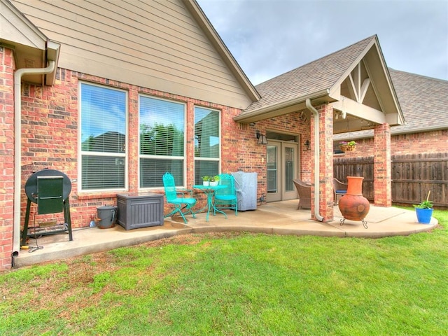 back of house featuring fence, a yard, a patio area, and brick siding