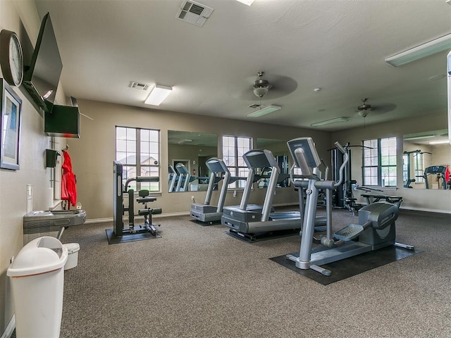 gym with baseboards, carpet, a ceiling fan, and visible vents