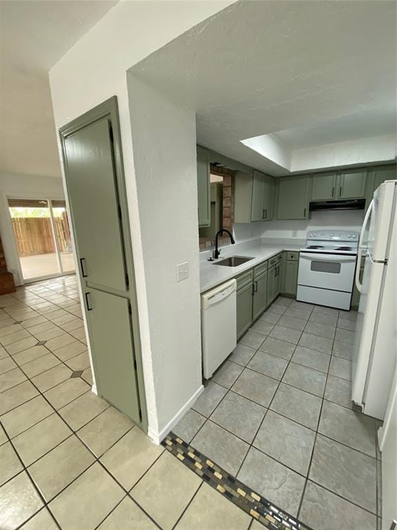 kitchen featuring light tile patterned floors, white appliances, under cabinet range hood, and a sink