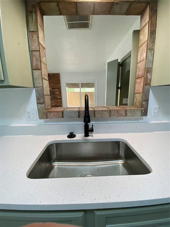 room details featuring a sink, visible vents, and green cabinets