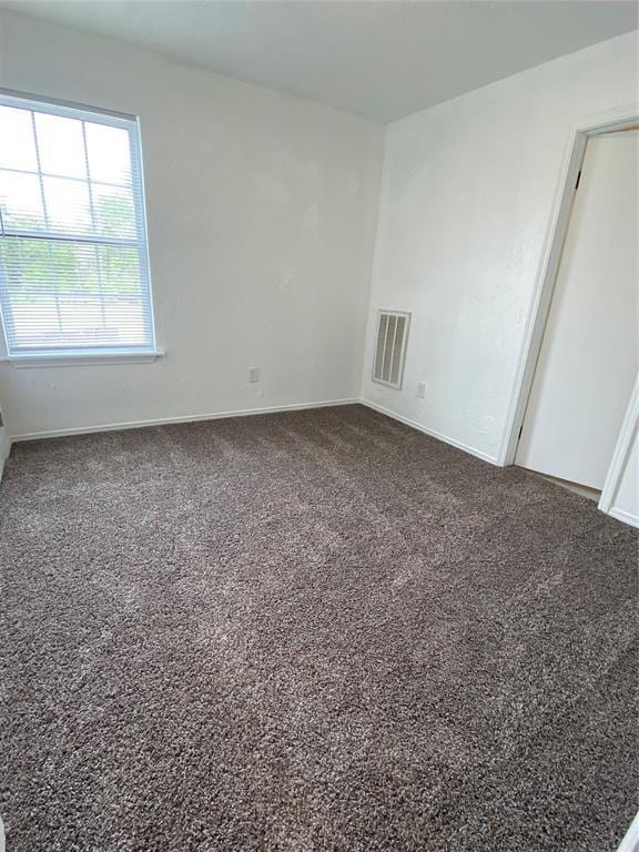 spare room featuring visible vents, carpet flooring, and baseboards