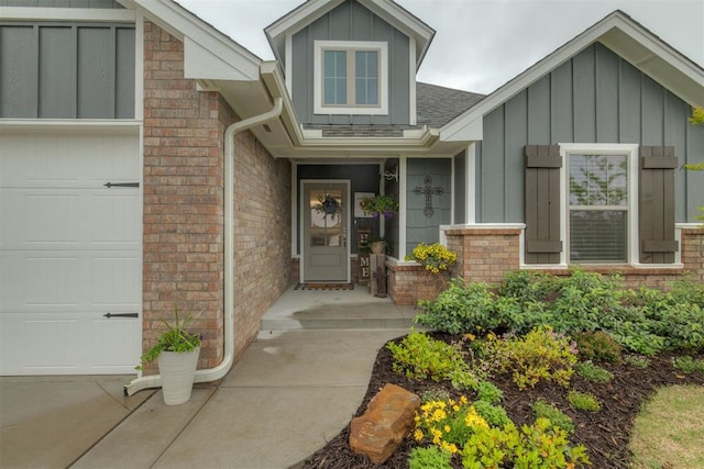view of exterior entry featuring brick siding, a shingled roof, and board and batten siding