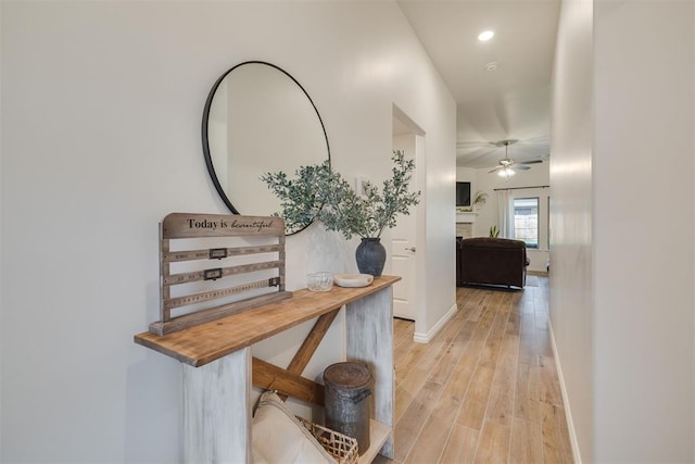 hall with light wood-type flooring and baseboards