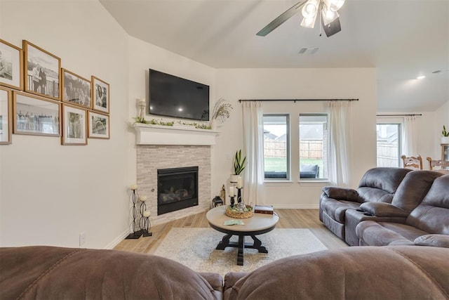 living area featuring visible vents, light wood-style floors, ceiling fan, and baseboards