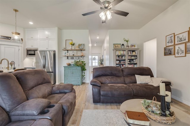 living room featuring recessed lighting, ceiling fan, baseboards, and light wood-type flooring