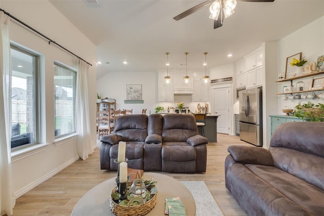 living room featuring light wood-style floors, a ceiling fan, baseboards, recessed lighting, and visible vents