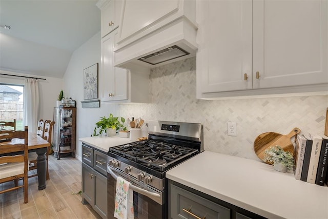 kitchen featuring light countertops, stainless steel gas range, and tasteful backsplash