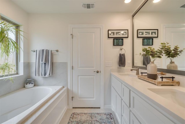 full bathroom featuring a sink, tile patterned flooring, double vanity, visible vents, and a bath