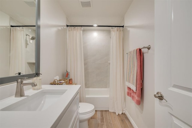 bathroom with visible vents, vanity, wood finished floors, toilet, and shower / bathtub combination with curtain