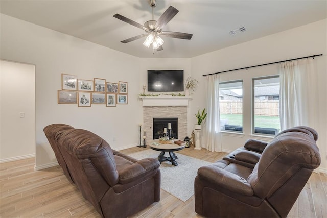 9304 NW 89th St, Yukon, OK 73099 - living area featuring ceiling fan, light wood-style floors, and a stone fireplace
