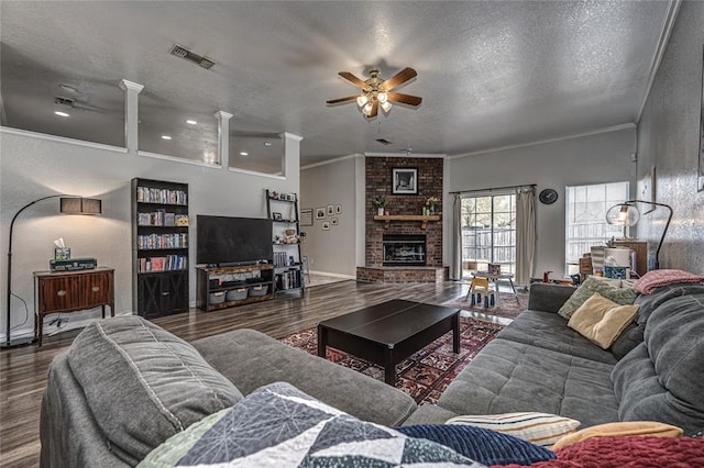living room featuring ceiling fan, ornamental molding, wood finished floors, and visible vents