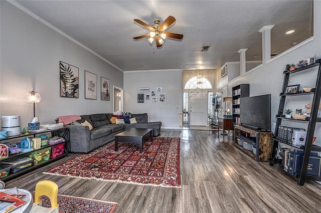 living room featuring a ceiling fan, a textured ceiling, visible vents, wood finished floors, and ornamental molding