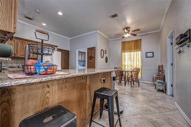kitchen with visible vents, decorative backsplash, a peninsula, and ceiling fan