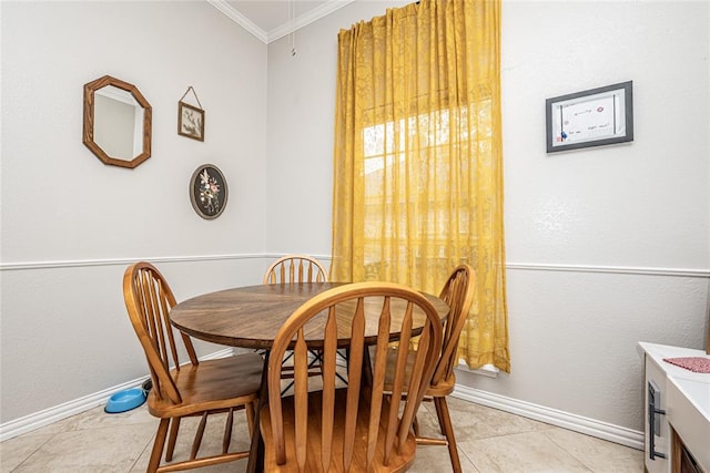 dining area featuring baseboards, ornamental molding, and light tile patterned floors