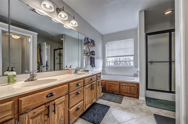 bathroom with a sink, tile patterned flooring, a shower stall, and visible vents