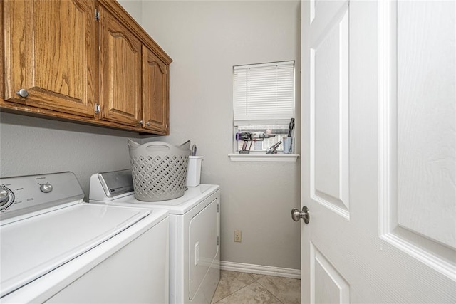 washroom featuring light tile patterned floors, baseboards, independent washer and dryer, and cabinet space