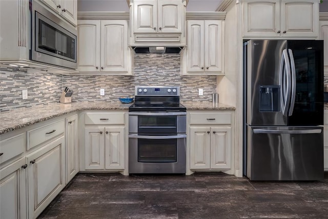 kitchen featuring light stone counters, dark wood-type flooring, appliances with stainless steel finishes, and tasteful backsplash