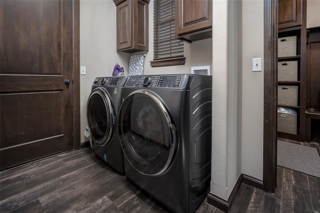 clothes washing area featuring cabinet space, dark wood-style flooring, baseboards, and washer and clothes dryer