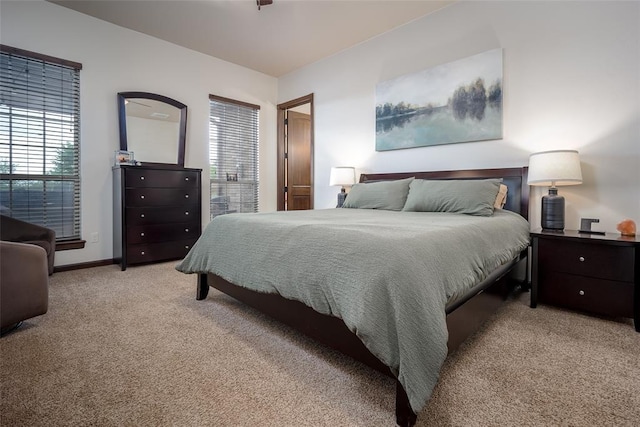 bedroom with baseboards and light carpet