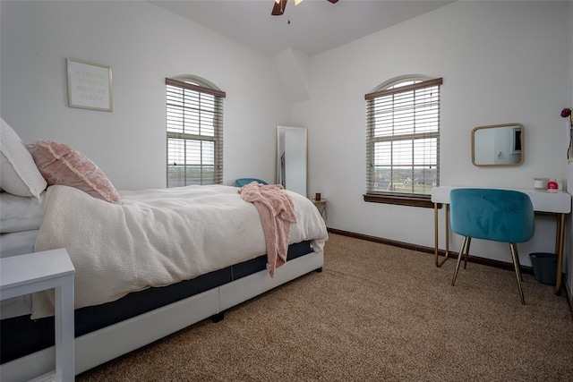 carpeted bedroom featuring baseboards, multiple windows, and a ceiling fan