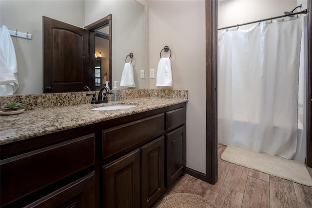 full bath featuring vanity, shower / bath combo, and wood finished floors