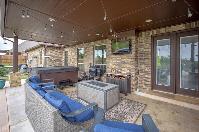 view of patio featuring a hot tub, fence, french doors, and an outdoor hangout area