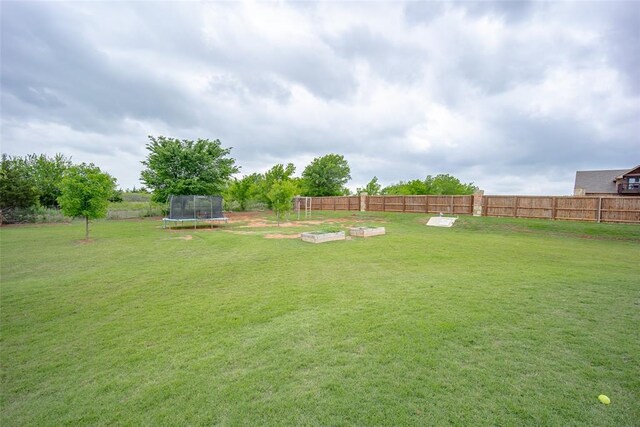 view of yard with fence and a trampoline