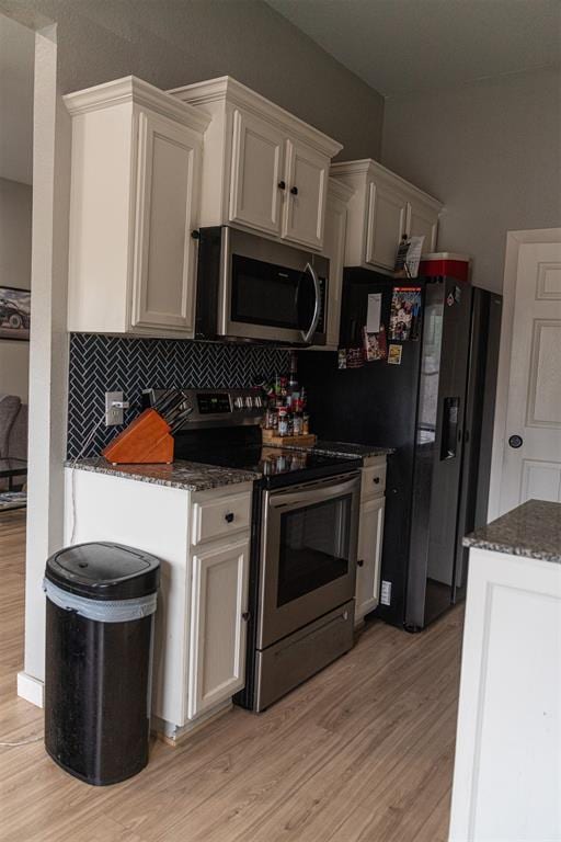 kitchen featuring backsplash, appliances with stainless steel finishes, and light wood-style floors