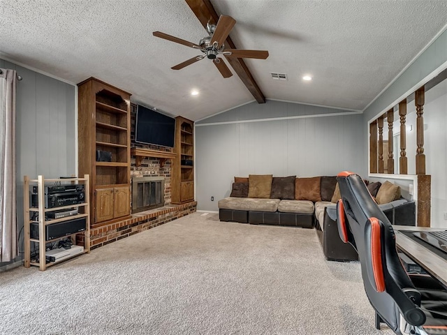 living room with ceiling fan, a fireplace, a textured ceiling, and visible vents
