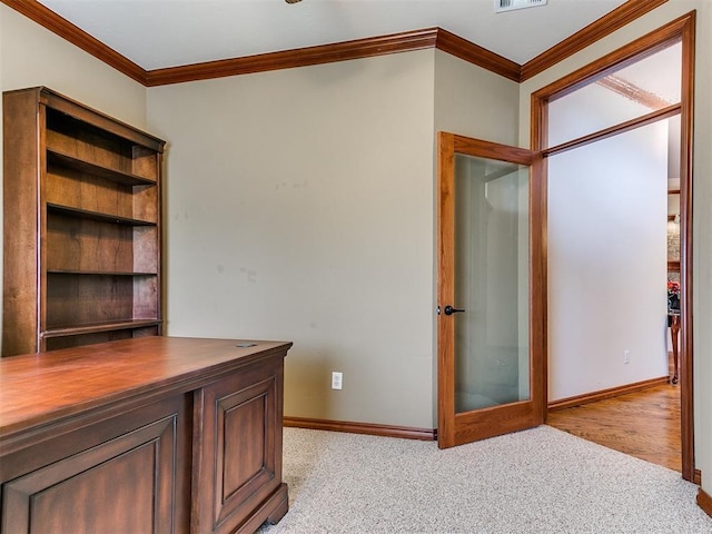unfurnished office featuring crown molding, baseboards, light carpet, and visible vents