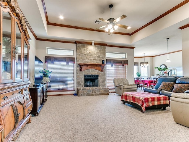 carpeted living room with a ceiling fan, visible vents, ornamental molding, and a raised ceiling