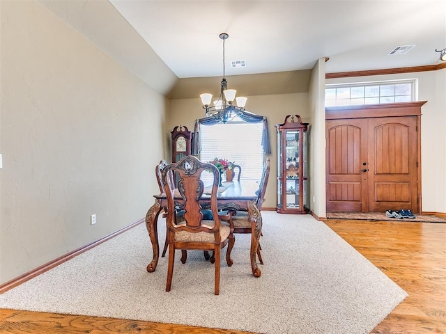 dining room featuring baseboards, visible vents, and a notable chandelier