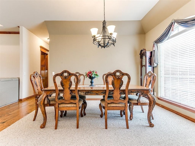 dining space featuring baseboards and a notable chandelier