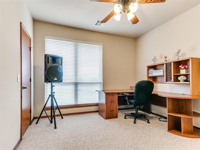 carpeted office space featuring baseboards, ceiling fan, and visible vents