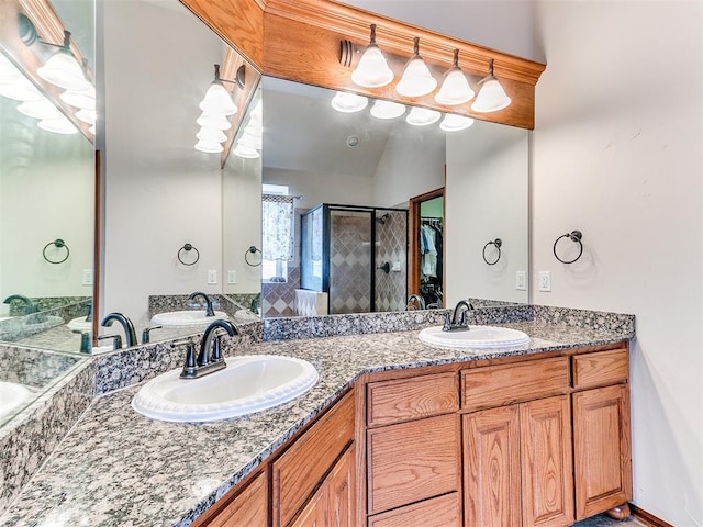 bathroom with double vanity, a sink, and a stall shower