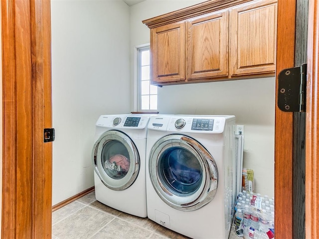 washroom featuring light tile patterned floors, cabinet space, and washer and dryer