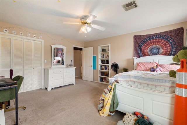 bedroom with ceiling fan, visible vents, light carpet, and a closet