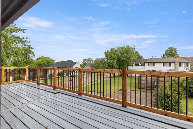 deck featuring a lawn, fence, and a residential view