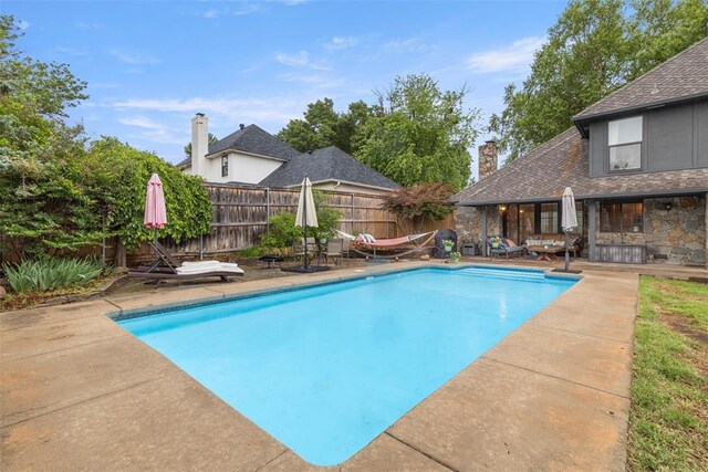 view of swimming pool featuring fence, a fenced in pool, and a patio area