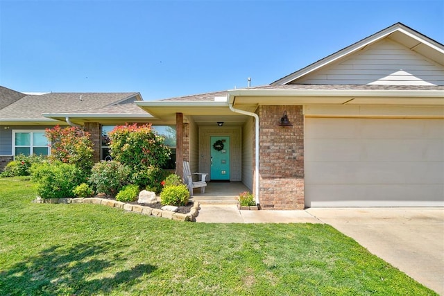view of front of house featuring a shingled roof, a front lawn, brick siding, a garage, and driveway