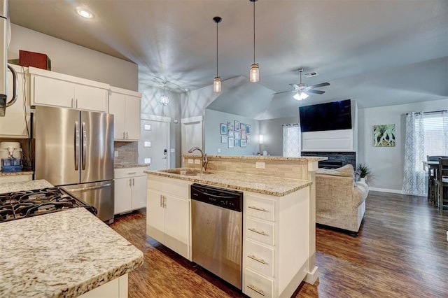 kitchen with pendant lighting, a sink, tasteful backsplash, a ceiling fan, and appliances with stainless steel finishes