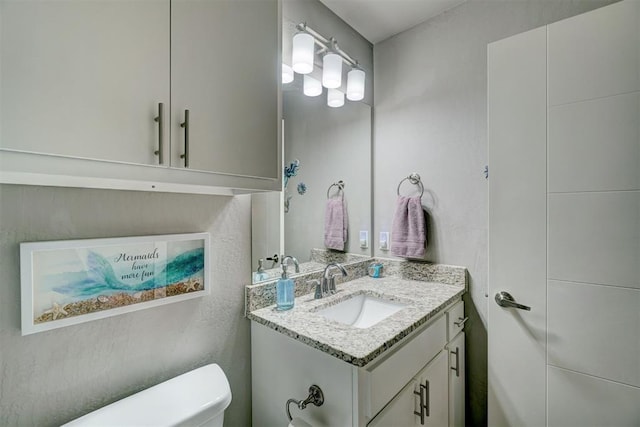 bathroom featuring toilet and vanity