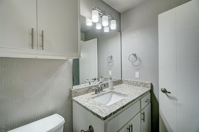 half bath featuring toilet and vanity