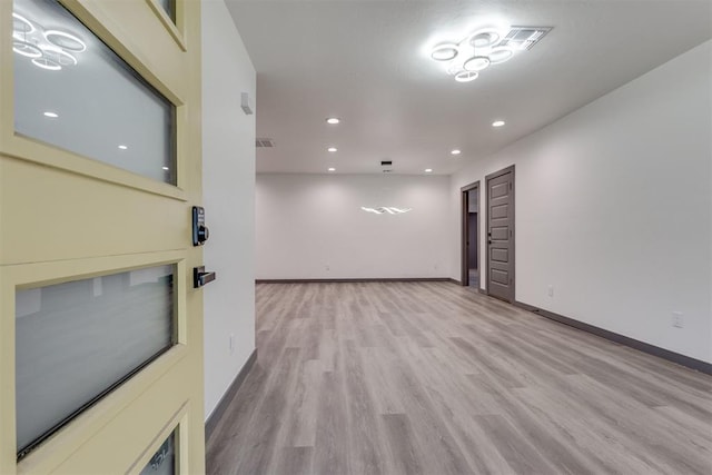 unfurnished room featuring baseboards, recessed lighting, light wood-style flooring, and visible vents