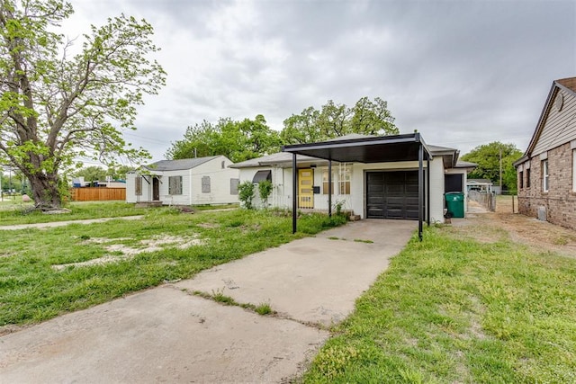 view of front of home featuring fence, an attached garage, driveway, and a front lawn
