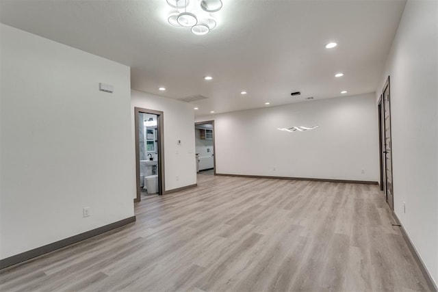 spare room with baseboards, recessed lighting, and light wood finished floors