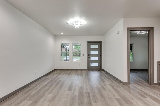 foyer entrance featuring light wood-style floors and baseboards