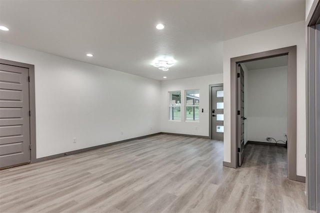 unfurnished room featuring recessed lighting, baseboards, and light wood-type flooring