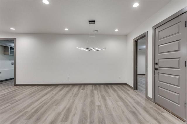 spare room with recessed lighting, baseboards, and light wood-style floors